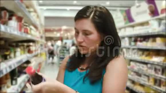 女人选择超市里的酱汁视频的预览图