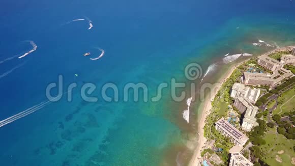夏威夷毛伊岛上水晶般干净的海洋船只和时髦的度假胜地海特海海岸线的空中拍摄视频的预览图