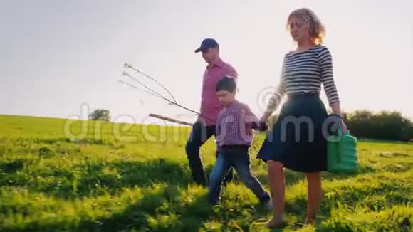 一家农民带着一个小儿子一起去种树承担苹果树苗铲子和浇水垫视频的预览图