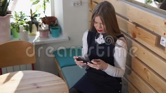 年轻漂亮的女人微笑着在手机上和她的朋友聊天视频的预览图