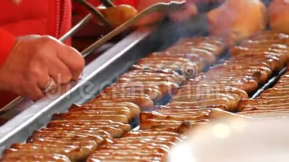 女人烤很多美味的新鲜德国香肠在新鲜包子附近准备了大量的纽伦堡香肠视频的预览图