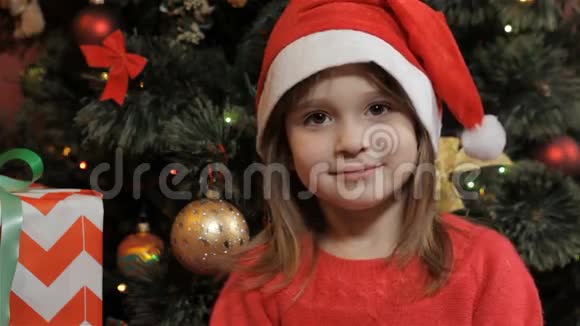 小女孩戴着圣诞老人帽子摆姿势视频的预览图