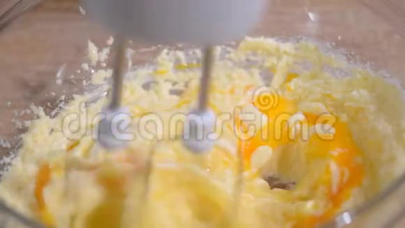 黄油糖和鸡蛋用搅拌器搅打视频的预览图