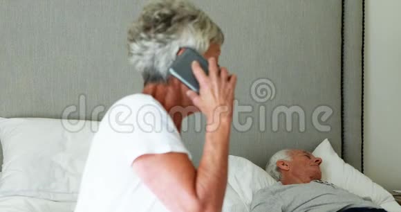 生病的老人躺在床上女人在打手机视频的预览图