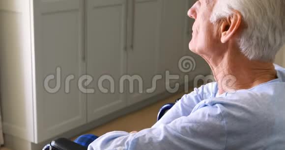 坐在轮椅上的老人透过卧室的窗户看着视频的预览图