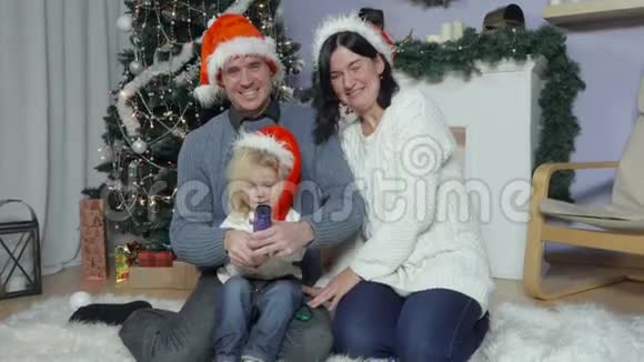 戴着圣诞帽和宝宝幸福家庭视频的预览图