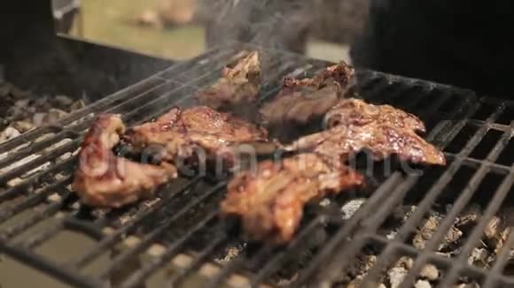 厨师在烤架上翻来覆去的是开胃的热猪肉排骨视频的预览图
