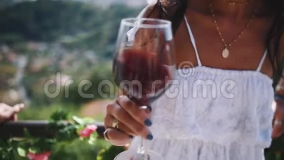 年轻女性的手在户外摇一杯红酒视频的预览图