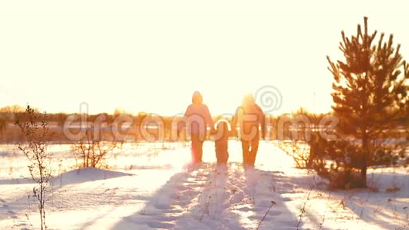 冬天有孩子在夕阳下散步的幸福家庭视频的预览图
