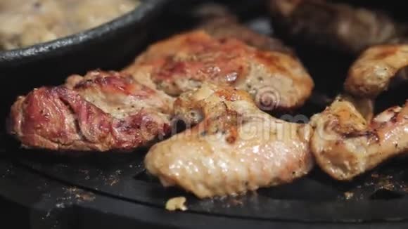 烤架上烤鸡翅和肉片的特写镜头视频的预览图