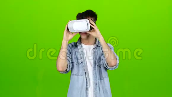 戴着虚拟眼镜的人正在看一部有趣的电影绿色屏幕视频的预览图