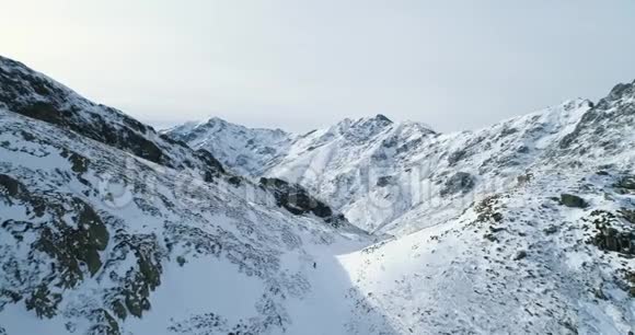 冬季前空中飞雪山口登山滑雪者向上攀爬视频的预览图