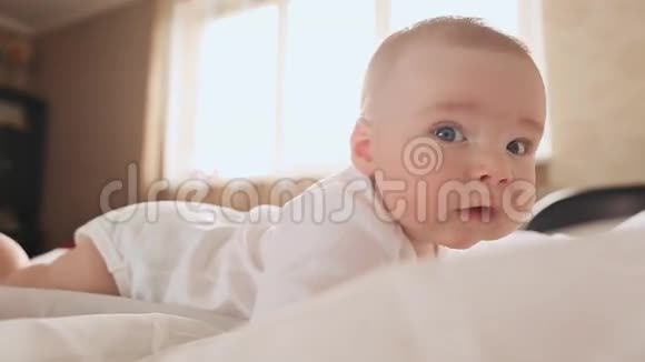 四个月大的婴儿躺在床上躺在家里的肖像视频的预览图