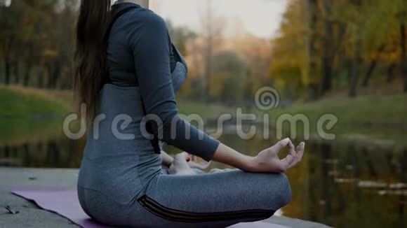 年轻女子在户外练习瑜伽女性冥想户外美丽的秋天自然视频的预览图