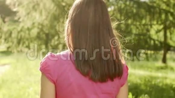 慢动作Pov女性在公园散步放松暑假面带微笑后面跟着摄像机视频的预览图