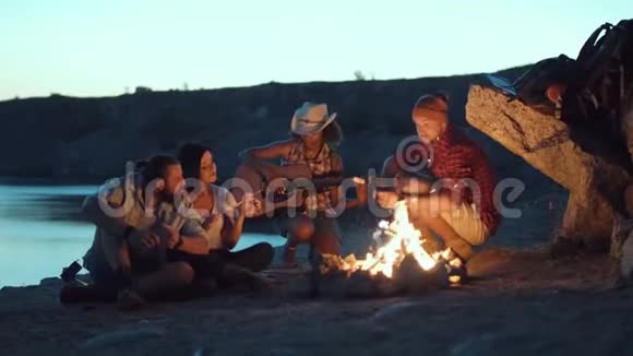 旅行者在岸上的篝火旁放松视频的预览图