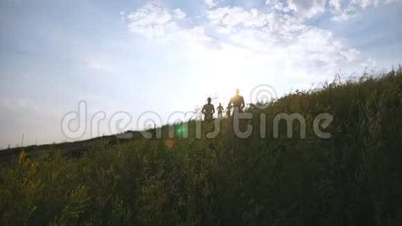 一群年轻人在蓝天上空的青山上奔跑背景是太阳耀斑男运动员正在慢跑视频的预览图