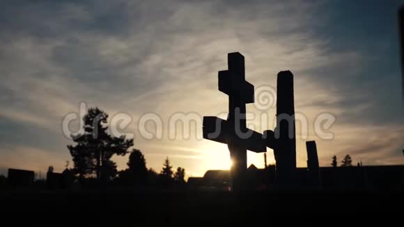 死亡生命的概念墓地在日落十字形生活剪影的坟墓后面穿过阳光的闪烁视频的预览图