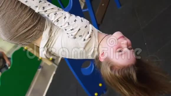 女孩把腿挂在操场的铁梯上视频的预览图