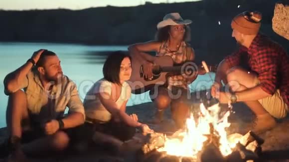 旅行者在岸上的篝火旁放松视频的预览图