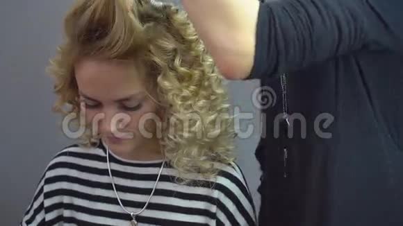 美丽的金发女孩长发理发师在美容院做非洲卷发专业美发护理视频的预览图