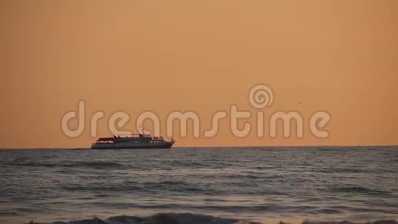 日落背景下波涛汹涌的海面上的船影视频的预览图