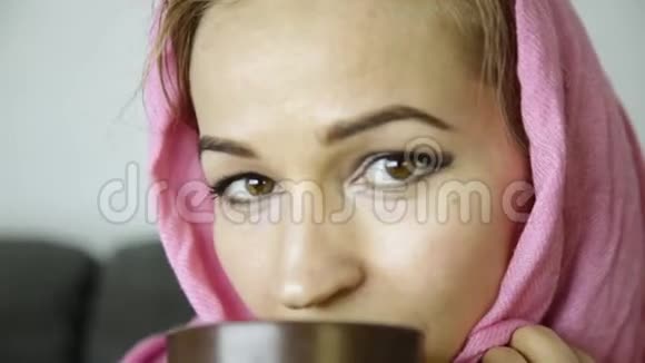身着粉色头巾的阿拉伯女人喝咖啡视频的预览图