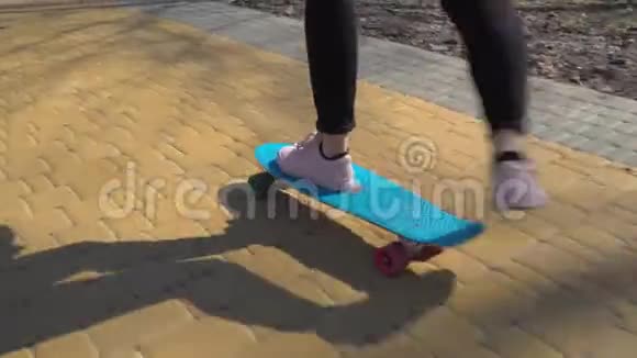 穿运动鞋的女孩在路上玩滑板视频的预览图