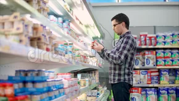 成年人在超市的货架上选择婴儿食品视频的预览图