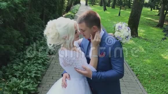 新婚幸福牵着手在公园散步拥抱亲吻视频的预览图