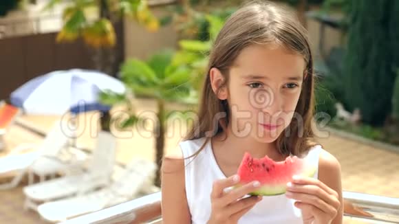 美丽的黑发小女孩长发在外面吃西瓜慢动作视频的预览图