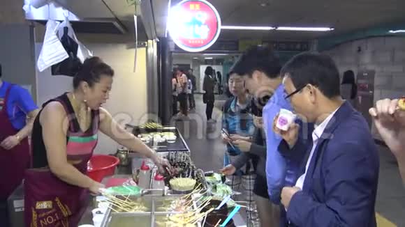 朝鲜街食品人们吃鱼饼和其他小吃视频的预览图