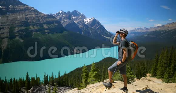 男子徒步旅行者在4k乡村的岩石上用望远镜观察视频的预览图