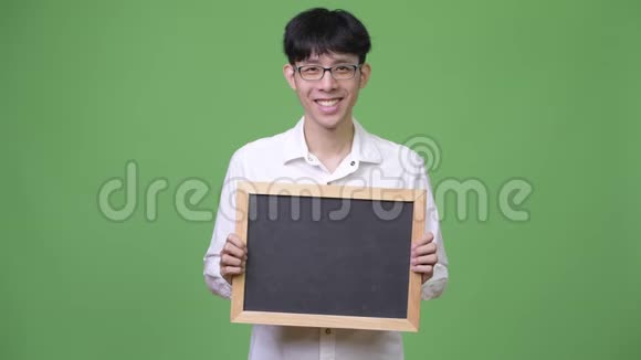 快乐的年轻亚洲商人捧着黑板微笑视频的预览图