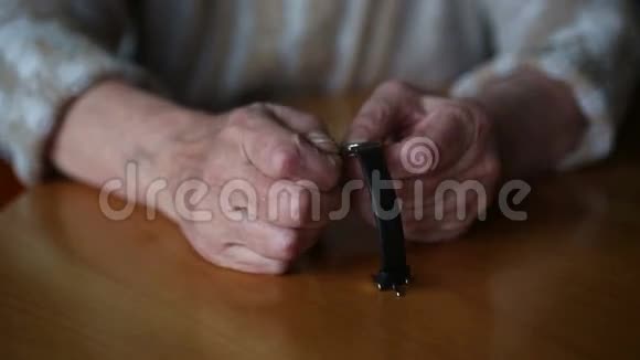 这位老妇人的手她的手表上设定时间视频的预览图