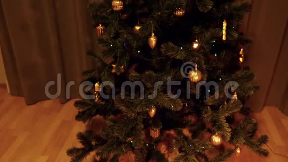 起重机向室内倾斜近距离射击圣诞树与仙女灯电花环闪烁礼品盒视频的预览图