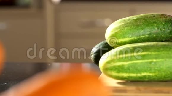 女人切黄瓜雌性手切绿色黄瓜环一把大刀在厨房里木板骄傲的女人新鲜c视频的预览图