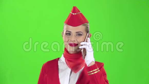 穿红色西装的女服务员在电话里讲话绿色屏幕慢动作视频的预览图