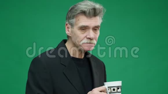 老人在绿色背景下喝咖啡视频的预览图