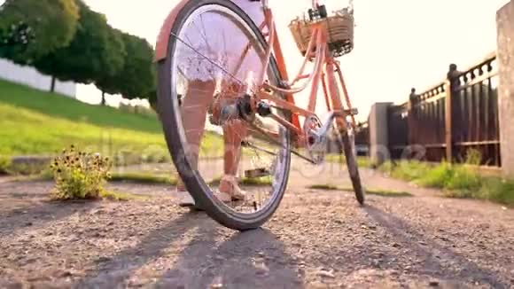 日落时年轻漂亮的女人骑着自行车走路慢动作视频的预览图