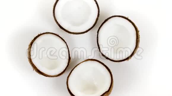 四个成熟的椰子半部分美味的果肉旋转在白色孤立的背景可循环无缝视频的预览图