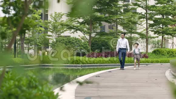 亚洲父亲护送儿子去花园慢动作学校视频的预览图