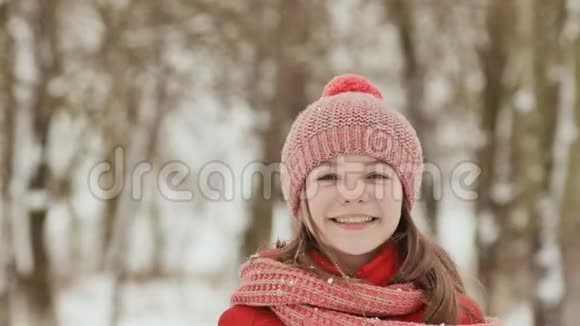 一个年轻的女学生高兴地扔了一个雪球当它落下时它用手掌打破它喜悦的情绪冬天的乐趣视频的预览图
