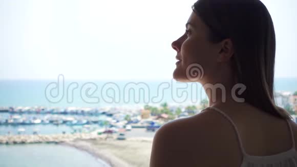 从露台欣赏海景的女人剪影从阳台看码头的女性旅行者视频的预览图