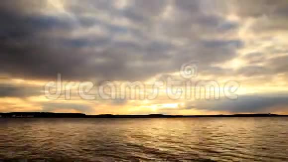 湖岸的水面上日落天空乌云密布视频的预览图