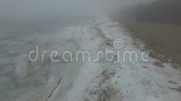 孤独的人走过冰雪覆盖的海洋海岸线视频的预览图