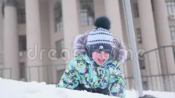 一个小孩子在雪山上玩扔雪笑晴朗的霜天新鲜空气中的乐趣和游戏视频的预览图