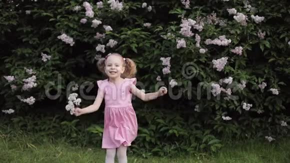 开心地笑着有趣的小女孩跳着夏园慢动作视频的预览图