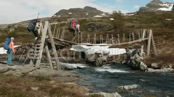 背包客通过挪威的河流上桥视频的预览图