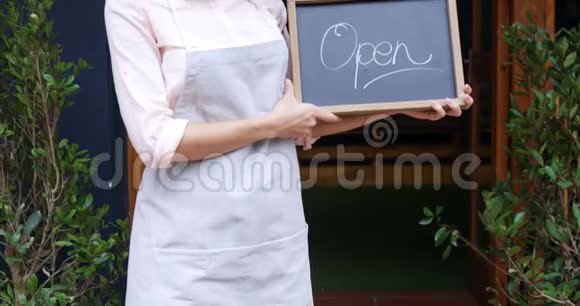 女服务员站在4k开放式标牌上视频的预览图